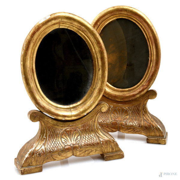 Coppia di specchierine da toletta in legno dorato a serto ovale, XX secolo, cm 34x25x10,5, (segni di usura, scalfiture, fessurazioni, restauri, perdite di doratura, difetti)