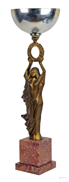 Coppa con vittoria art déco in metallo dorato, cm h 43, base in marmo, XX secolo, (alt. base cm 10), (segni del tempo).