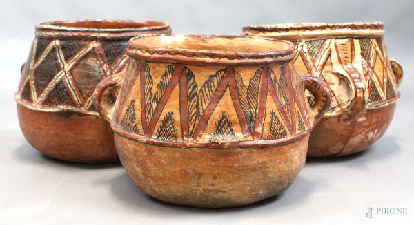 Tre vasi biansati in terracotta smaltata, con decori policromi a motivi geometrici, misure max cm h25x40x37, (difetti).