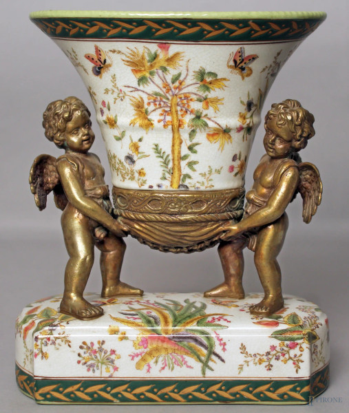 Alzata centrotavola in maiolica con decori floreali retta da putti in bronzo, H 26 cm.