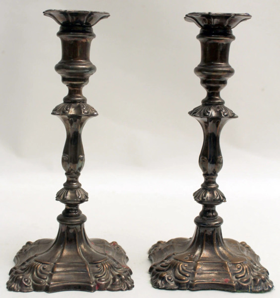 Coppia candelieri ad una luce in metallo argentato e cesellato, H. 24 cm.