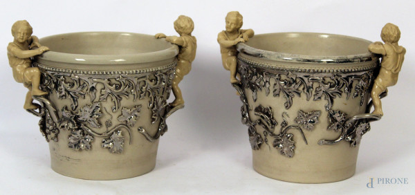Coppia di portavasi in ceramica smaltata con decori di tralci di vite argentati e fanciulli a rilievo, h. cm 20.