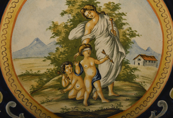 Coppia di grandi piatti decorativi raffiguranti nel cavetto scene di ispirazione mitologica in am...