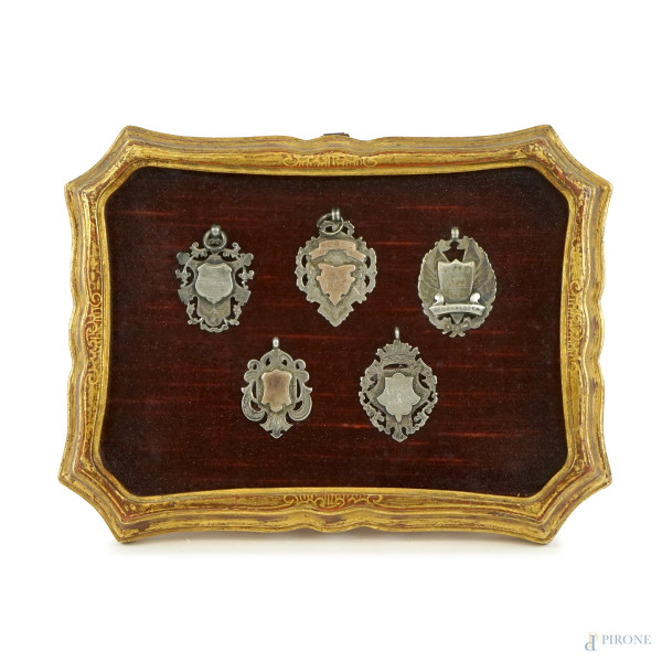 Teca in legno dorato contenente cinque medaglie in argento, misure ingombro cm 15,5x20