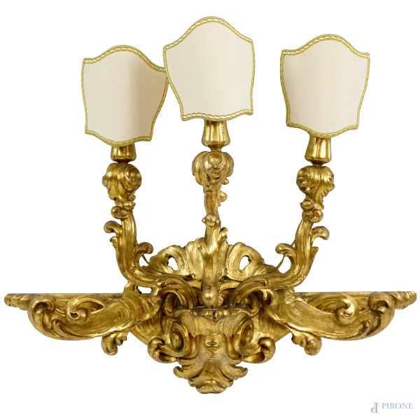 Applique a tre luci in legno intagliato e dorato, XIX secolo, max h cm 47 (difetti)