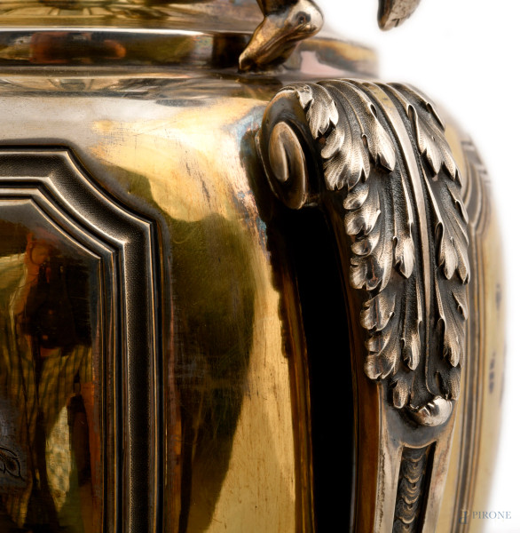 Grande vaso biansato in argento con prese a guisa di putti su foglie d'acanto a sorreggere l'orlo...