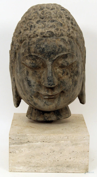 Testa di budda, scultura in pietra poggiante su base in travertino, H 31 cm.