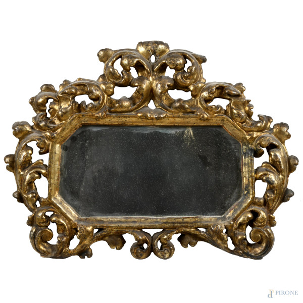 Specchierina in legno dorato e intagliato a volute, XX secolo, cm 38,5x50, (segni di usura, difetti, cadute di doratura, rotture, restauri, fori di tarlo)