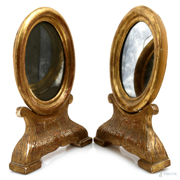 Coppia di specchierine da toletta in legno dorato a serto ovale, XX secolo, cm 34x25x10,5, (segni...