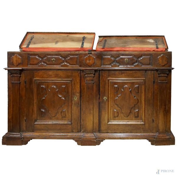 Credenza in legno di noce intagliato, a doppia anta e interno a doppio ripiano, con piano biparti...