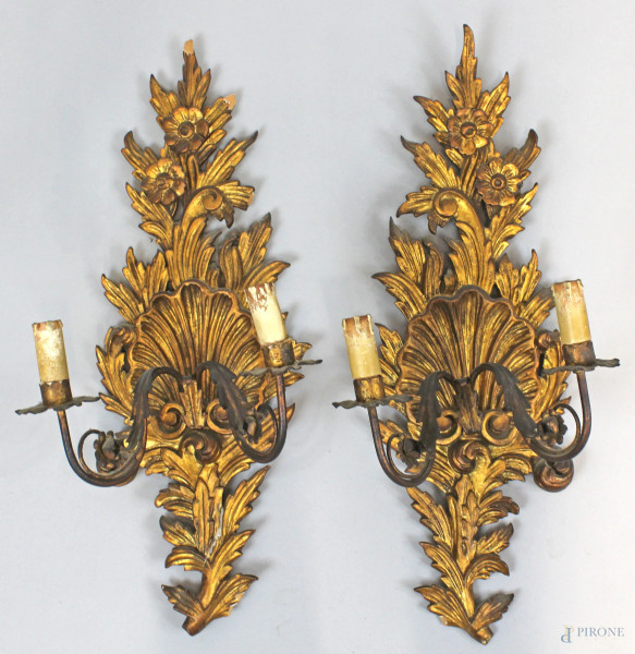 Coppia di appliques in legno intagliato e dorato, due braccia a volute in metallo, XX secolo, alt. cm 61, (lievi difetti)