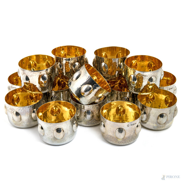 Lotto di 16 bicchieri in argento Brandimarte con decorazioni a sbalzo e interno vermeil, XX secolo, peso complessivo gr 1950, cm 6x9