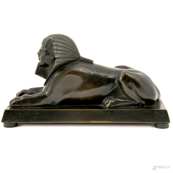 Scultura in metallo brunito su base rettangolare, inserita all'interno di teca in plexiglass con ...