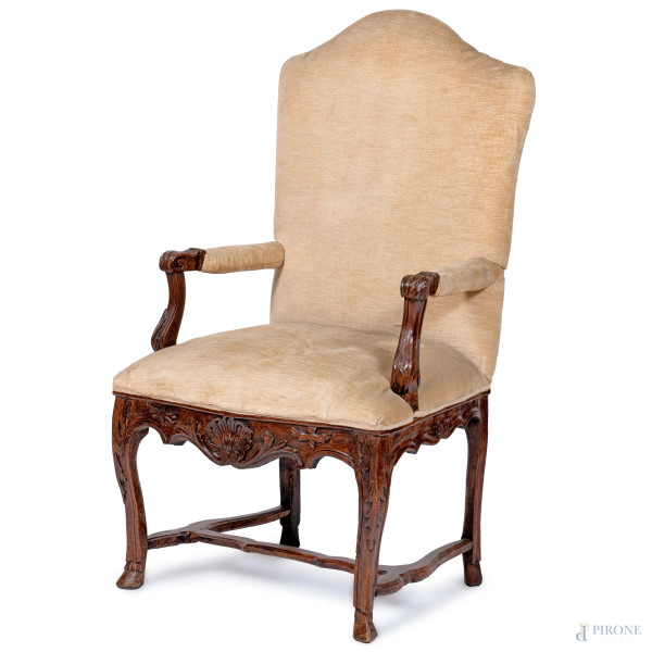 Poltrona in noce con gambe raccordate. Schienale, seduta e braccioli imbottiti e rivestiti in tessuro panna, XX secolo, cm 122x70x55, (segni di usura, difetti)