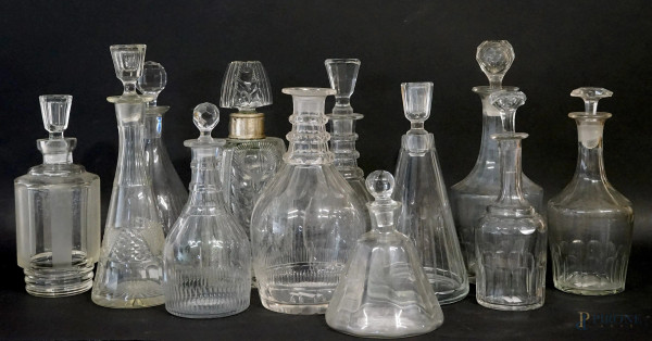 Lotto di dodici ampolle in vetro e cristallo controtagliato, alt.max cm 30,5, XX secolo, (difetti, mancante un tappo).