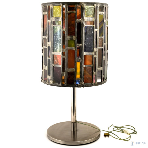 Lampada in metallo argentato, con base circolare e paralume cilindrico in metallo argentato e inserti rettangolari in vetro di vari colori e dimensioni, XX secolo, altezza cm 73, (difetti)