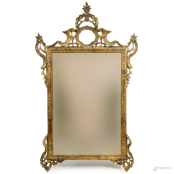 Specchiera in legno intagliato e dorato a volute, XX secolo, cm 150x91, (difetti)
