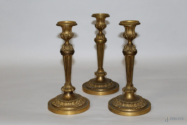Lotto composto da tre candelieri in bronzo dorato, inizi XX sec., H 24 cm.