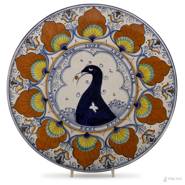 Piatto in maiolica policroma, cavetto decorato con un pavone e tesa a motivi floreali, Faenza, XX secolo, diametro cm 31 (difetti)