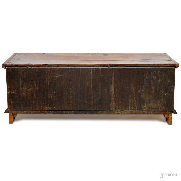 Cassapanca in noce modanato con fronte scandito da tre sezioni contenenti rispettivamente al cent...