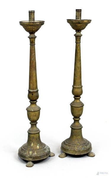 Coppia di candelieri in metallo dorato, fusto poggiante su base a tre zampe zoomorfe, cm h 64, XX secolo, (difetti).