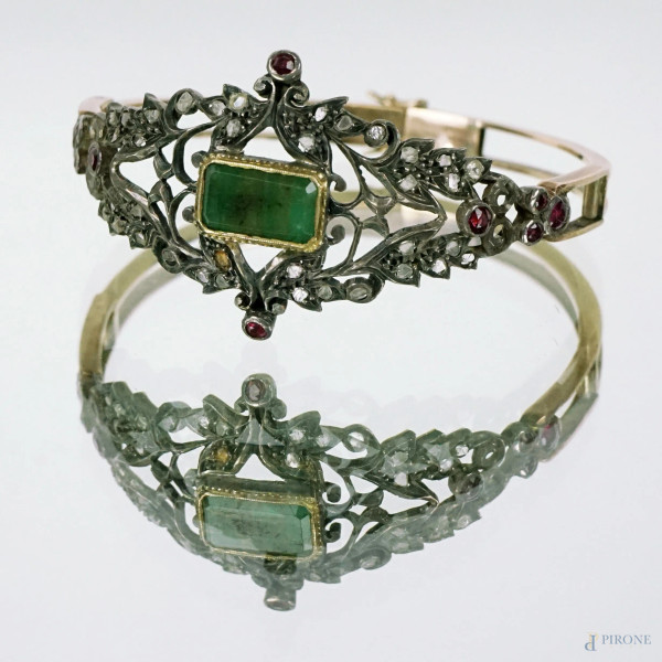 Antico bracciale rigido in argento dorato, finemente lavorato, con schegge di diamante, rubini e smeraldo, inizi XX secolo