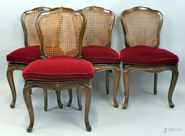 Quattro sedie in noce con sedute e schienali cannettè, gambe mosse, cuscini in velluto rosso, XIX secolo