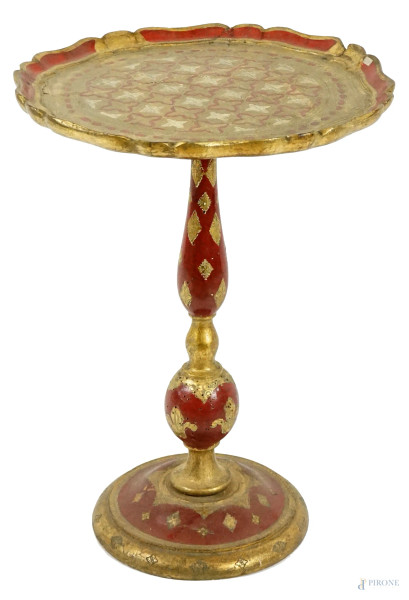 Tavolino fiorentino, XX secolo, in legno dorato e laccato rosso con decori incisi, piano di linea sagomata, gamba a balaustro poggiante su base circolare, cm h 52x40x40, (difetti)