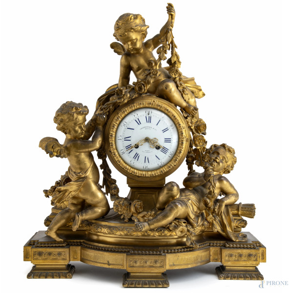 Orologio da camino in bronzo dorato riccamente decorati con tre putti allegorici reggifestoni realizzati a tutto tondo. XIX secolo, cm 67x57x20, (da revisionare)
