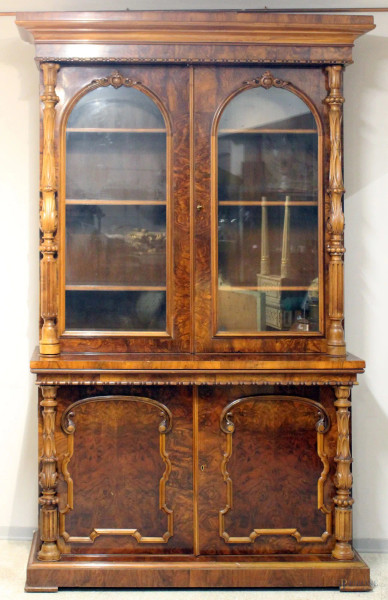 Bookcase a doppio corpo in noce e radica con colonne laterali intagliate, a quattro sportelli di cui due a vetri, cm 245x150x55, XIX sec.