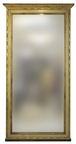 Specchiera  di linea rettangolare in legno intagliato e dorato a motivi di foglie d'acanto e dentelli, misure ingombro cm 209x99, misure luce cm 180,5x80, fine XIX-inizi XX secolo, (difetti).
