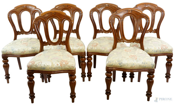 Sei sedie in noce, XX secolo, schienali intagliati a giorno, sedute rivestite in tappezzeria avana con decori floreali, quattro gambe a sciabola, cm  h, (difetti)