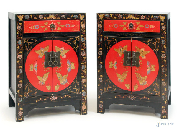 Coppia di comodini cinesi in legno laccato rosso e nero, fronte a un cassetto e due sportelli, decori a foglie e farfalle, cm 60x40x32,5, (difetti).