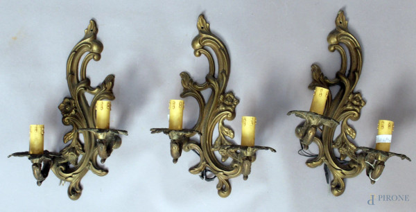 Lotto composto da tre appliques in bronzo a due luci, altezza 38 cm.
