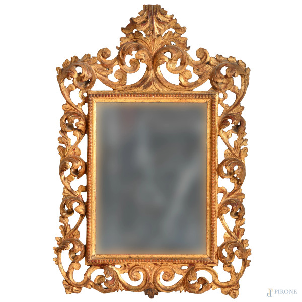 Specchiera in legno dorato e intagliato a volute vegetali, XX secolo, cm 73x48, (difetti)