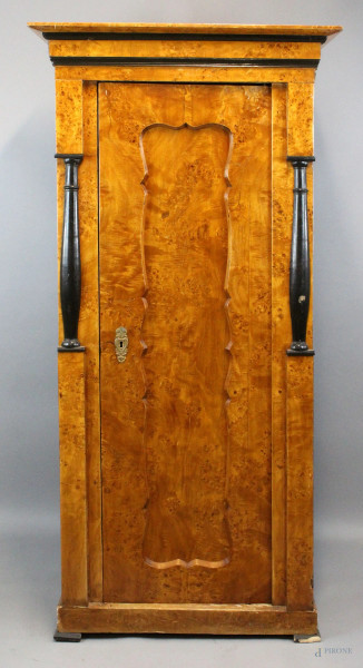 Armadio in radica di tuja, ad uno sportello inquadrato da colonne in legno ebanizzato, cappello modanato, altezza cm 180x86,5x58, XIX secolo