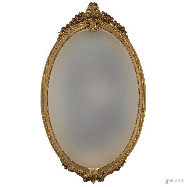 Specchiera a serto ovale in legno intagliato e dorato, XX secolo, cm 150x89, (segni di usura, scalfiture, rotture, difetti)