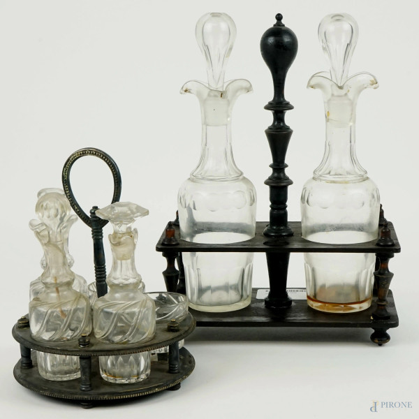 Lotto composto da due oliere con supporti in legno e metallo argentato, ampolle in vetro, alt. max cm 30, XX secolo, (difetti).