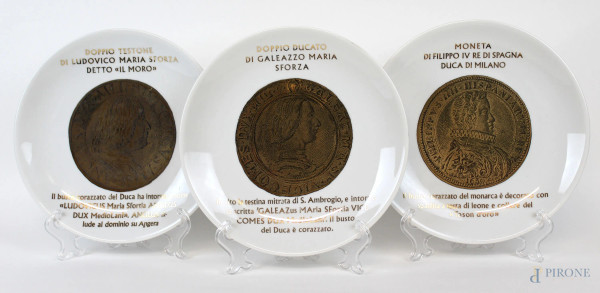 Piero Fornasetti - Set di tre piatti della serie "Monete del Ducato di Milano" in porcellana bianca con decori dorati, diam. cm 25, marchio della manifattura al verso.