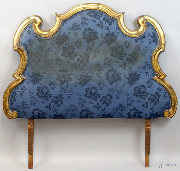 Testata di letto, XVIII secolo, cornice in legno intagliato e dorato, imbottita e rivestita in stoffa blu a fiori, cm 131x137, (difetti)