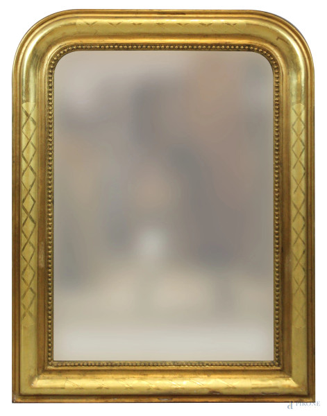 Specchiera di linea sagomata in legno intagliato e dorato, decori incisi, battuta interna a perlinatura, fine XIX secolo, cm 90x68
