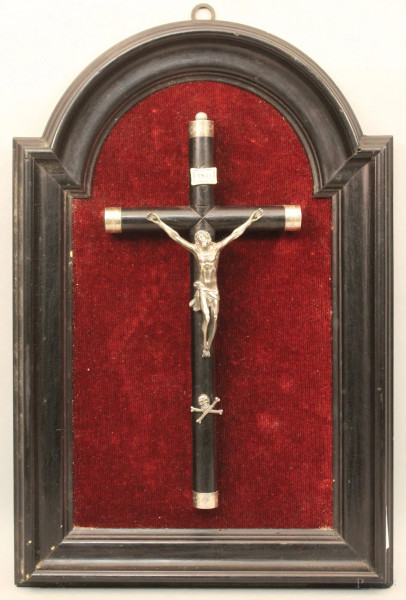 Cristo in argento con croce in legno ebanizzato con finali in argento, XIX sec., entro cornice sagomata, ( Cristo h cm 12, croce h cm 32).