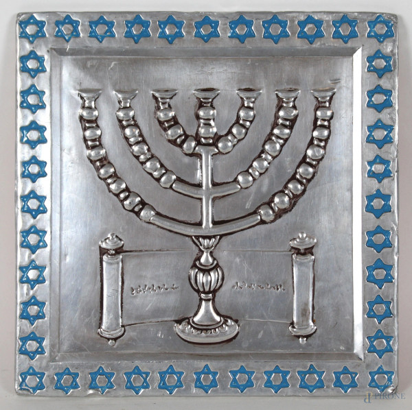 Placca in metallo argentato raffigurante la Menorah, bordi decorati con stelle a sei punte smaltate celesti, cm. 22x22.