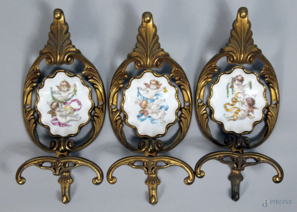 Tre appendiabiti in bronzo con formelle in porcellana decorate da putti musicanti, cm. 25x11x7, manifattura italiana, XX secolo