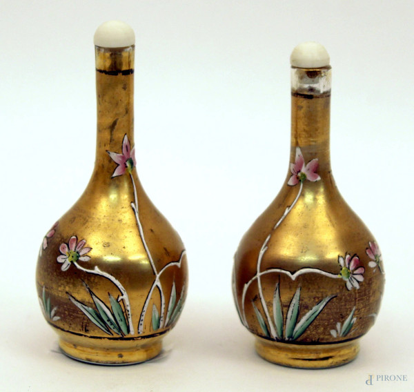 Coppia di snuff bottle in vetro dorato e dipinto a fiori, tappi in avorio, Cina, XX sec., H 10 cm.
