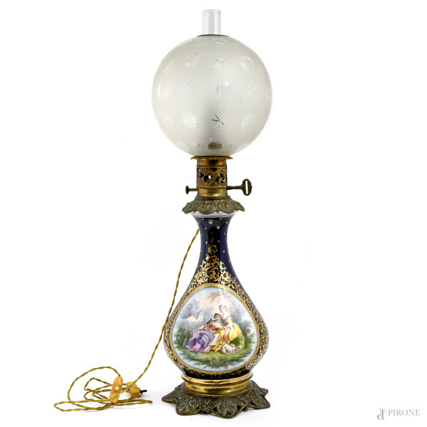 Lampada da tavolo in porcellana dipinta nei toni del blu e dell'oro con scena galante. Diffusore in vetro satinato, XX secolo, altezza complessiva cm 67, (segni di usura, difetti, da revisionare)