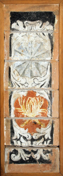 Pannello in terracotta dipinta a motivo di stemma araldico, XVIII sec., cm 32x102.