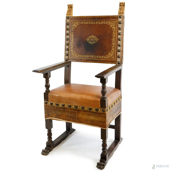 Poltrona in legno tinto a noce con particolari intagliati e dorati, schienale e seduta in pelle, inizi XX secolo, (segni del tempo).