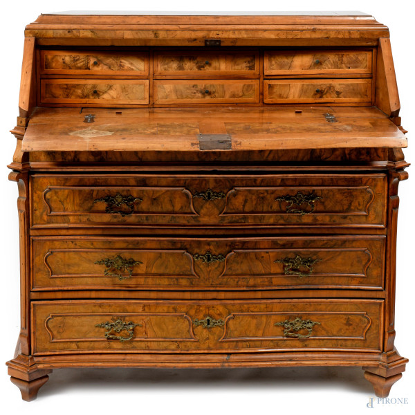 Ribalta in noce e radica, fronte scandito da tre cassetti con maniglie bronzee sormontati da spor...