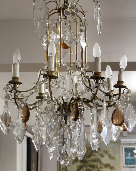 Coppia di lampadari ad otto luci in metallo dorato con gocce in cristalli, altezza 100 cm, XX secolo.